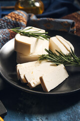Plate with delicious feta cheese with rosemary on color background