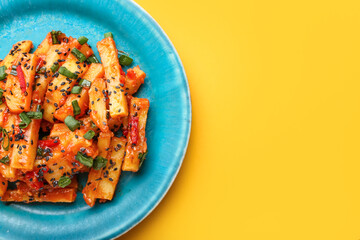 Plate with honey chilli potato on color background