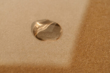 A drop of cosmetic product on a beige background. Texture.