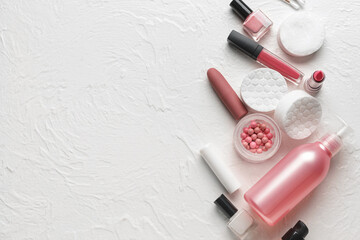 Different cosmetics, nail polishes and cotton pads on white background