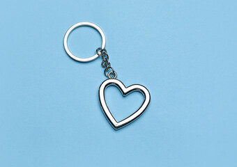 Silver heart shaped keychain with keyring on blue background