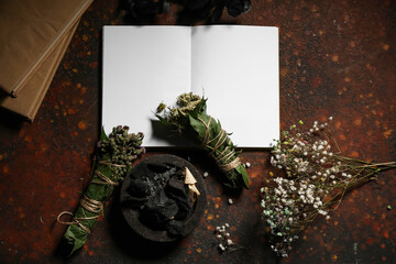 Witch's ritual with smoked ingredients and dried herbs on dark table background