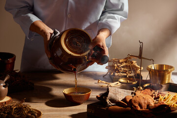 Traditional chinese medicine with herb and spices in brown wooden background doctor using a...