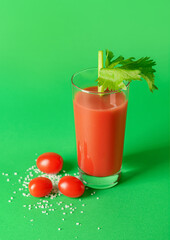 Glass of bloody mary with celery and tomatoes on color background