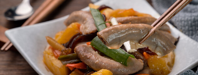 Eating pan-fried pork small intestine with pineapple.