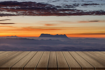 Fototapeta na wymiar Heaven at early sunrise predawn clear sky with orange horizon and red atmosphere over the mountains with the morning mist with Empty wooden table