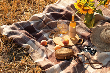 Festive picnic with sunflowers and wine on wheat field