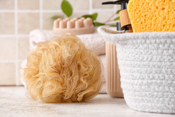 Sponge and basket with bath supplies on light table