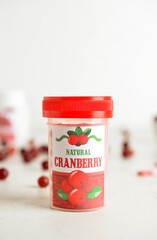 Bottle of healthy cranberry pills on table