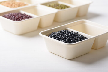 Black soybeans in compostable cardboard boxes are eco-friendly concepts and are mainly used as a plant-based ingredient in vegetarian, healthy food.