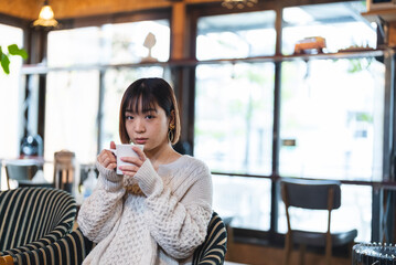 カフェでコーヒーを飲む若い女性