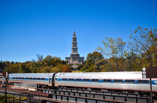 Alexandria, Virginia, USA - November 1, 2021: King Street  - Old Town WMATA Metro Station, looking at the George Washington Masonic Temple, with an Amtrak Train in the Foreground on a Fall Afternoon