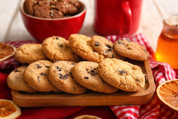 Board of tasty homemade cookies with chocolate chips on white wooden background, closeup