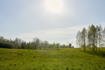 A rural area where an old mill is located in the distance