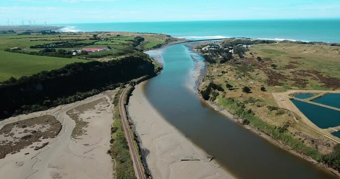 Panoramic aerial over Patea River, oceanfront, and vast wind farm - NZ