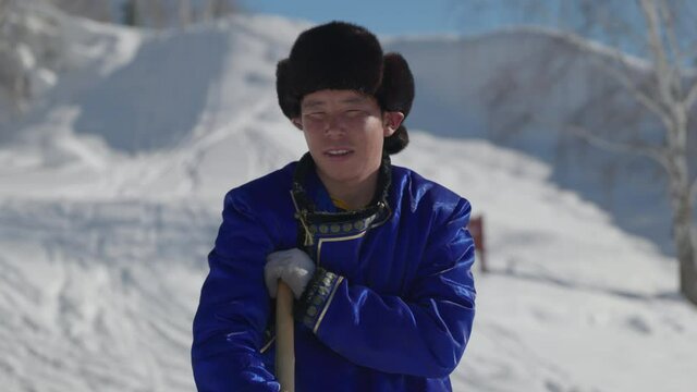 Portrait of Mongolian man dressed in traditional deel in winter.