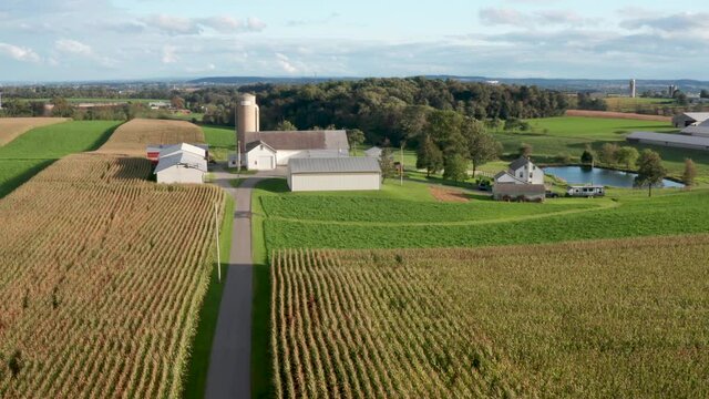 Aerial of drone flying in midair, recording video of beautiful ag family farm scene.