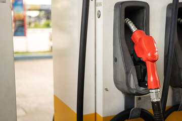 A Red color of refuel nozzle head at gasoline station. Transportation energy and equipment object photo. Close-up and selective focus.