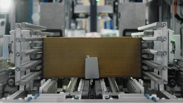 Goods being packaged in carton boxes by automated machinery; mechanization