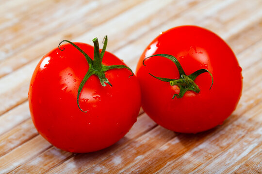 Image of red tomatoes on wooden table in home kitchen