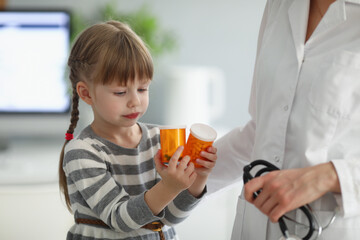 Child playing with bottles full of medication while on doctors appointment