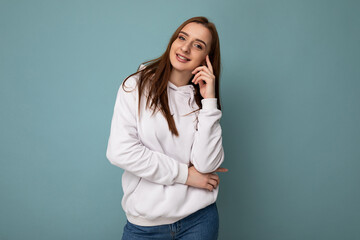 Photo shot of pretty joyful smiling young female person wearing casual trendy outfit standing isolated on colourful background with copy space looking at camera and having fun