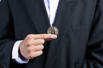 Fototapeta na wymiar Businessman wearing a suit holding a bitcoin, bitcoin concept.