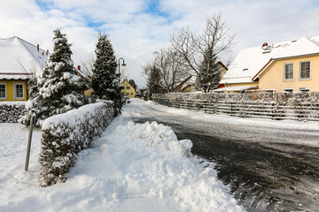 schneeberge an geräumter straße in einem wohngebiet zur winterzeit