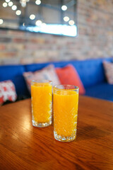 two glasses of orange juice on the table