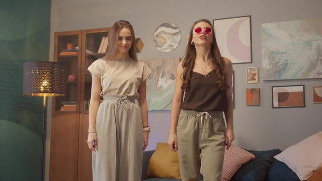 Teenagers womans shooting together dancing at home while making video for social media, stories hip hop popular trandy dance, students at home make content for network.
