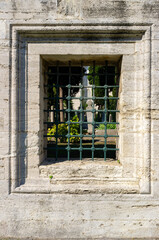 Fototapeta na wymiar Old stone wall with lattice windows in Suleymaniye Mosque in Istanbul
