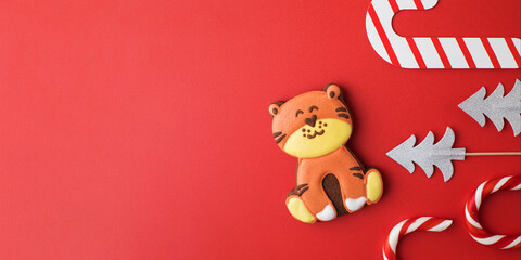 Gingerbread Christmas tiger on a red background. Year of the tiger according to the Chinese zodiac calendar. Copy space