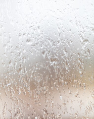 Frozen drops of water on a glass window as an abstract background.