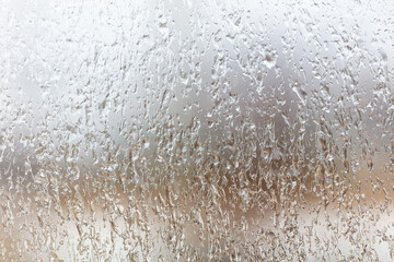 Frozen drops of water on a glass window as an abstract background.