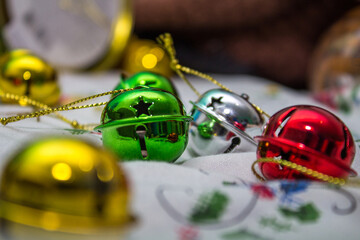 Multi-colored jingle bells on a light background. Selective focus. Close-up