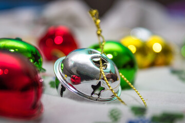 Multi-colored jingle bells on a light background. Selective focus. Close-up