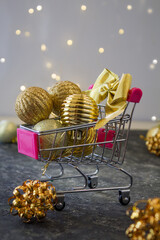 Christmas creative minimal composition. Shopping cart with Xmas 
gold decorations