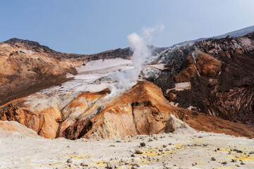 Panoramic amazing Kamchatka landscape of colorful rainbow volcanic mountains. Crater with active volcano smoke  © Valeria Mas