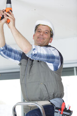 happy man is drilling the ceiling