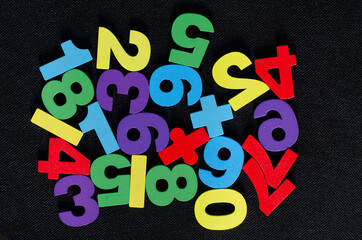 Top view of colorful wooden numbers on black background	