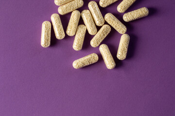 Magnesium capsules. Magnesium in transparent capsules with granules inside. Pills on a purple...