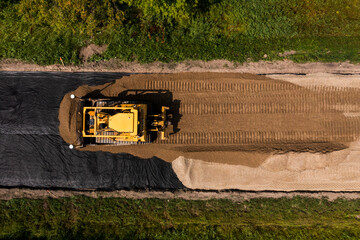 Top down shot of bull dozer building a brand new road. © Cody