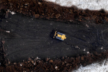 Top down shot of bull dozer pushing Pete moss into a pile.