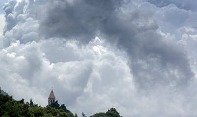 Wieża kościelna na tle pięknego nieba zjawiska pogodowe na niebie skłębione chmury burzowe