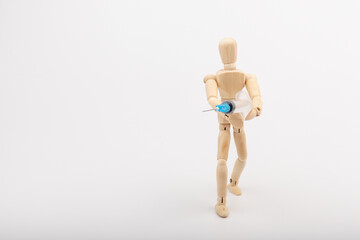 wooden mannequin with syringe against white background