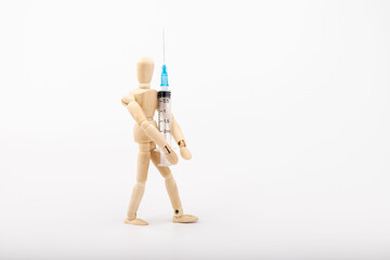 wooden mannequin with syringe against white background
