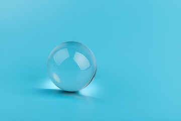 Crystal glass ball sphere transparent on blue background.
