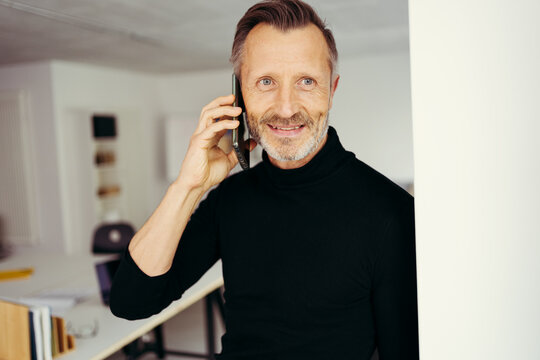 Portrait of amiddle-aged man smiling while talking on the phone