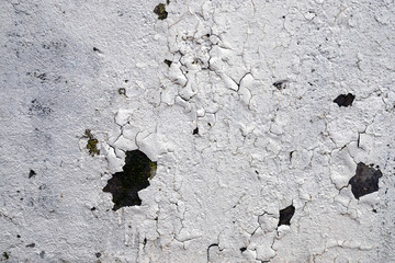 painted white wall and cracked from time with traces of rust and dirt background. Low-quality paint work.