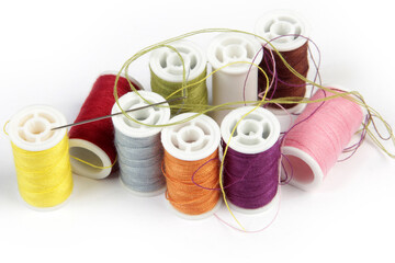 various colors of thread and sewing needle